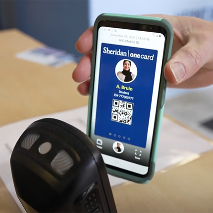 Close-up of university student using smartphone to perform tap for check-in with mobile ID