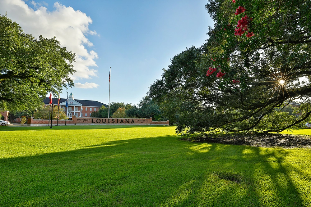 View of entrance of University of Louisiana at Lafayette among trees on cloudy but sunny day