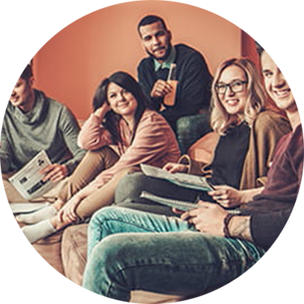 Circular image depicting five students seated on cushions and reading magazines in casual setting