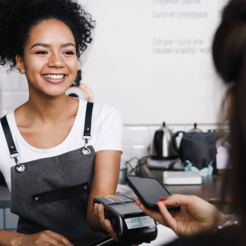 Owner of small business taking cashless payment from personal device of customer