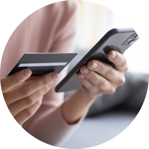 Cropped image of close-up of two hands using handheld device and payment card