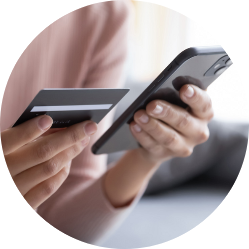 Cropped image of close-up of two hands using handheld device and payment card