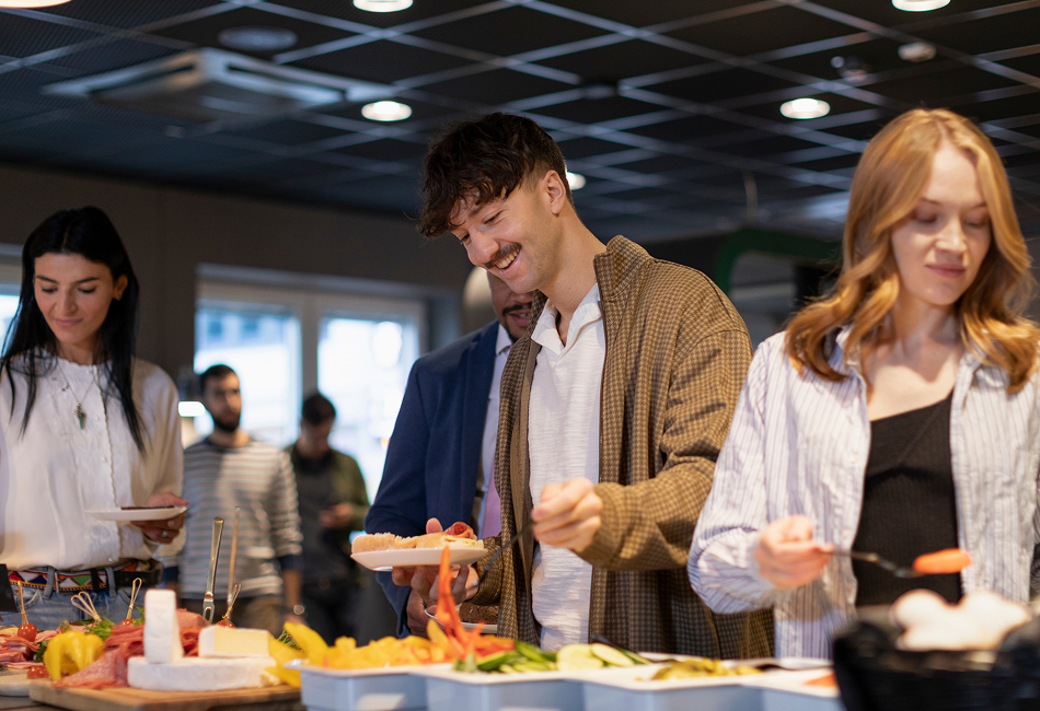 A group of college students fill their plates at a campus cafeteria.